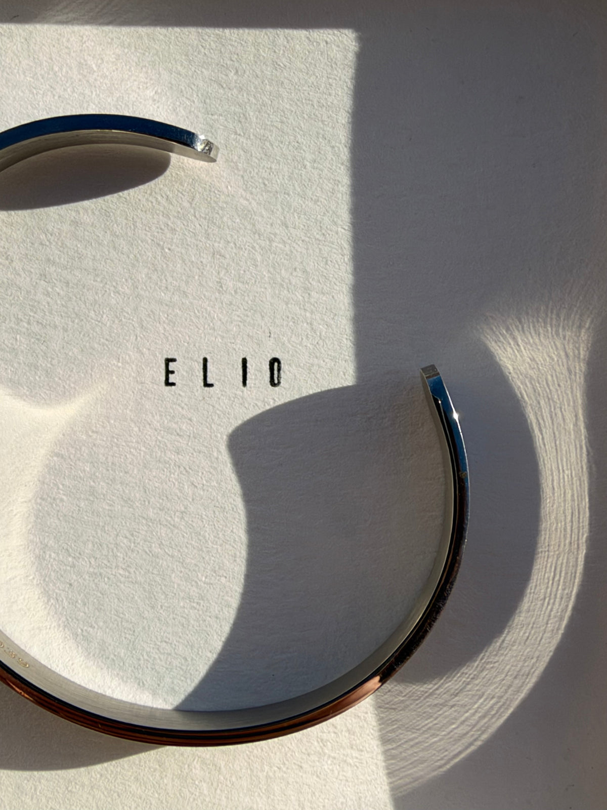 Jonc ELIO STEEL posé sur sa carte, acier poli miroir