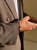 Jonc ELIO STEEL en acier poli miroir porté au poignet avec une veste en laine